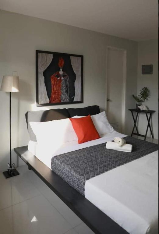 a bedroom with a large white bed with red pillows at SanRosa Boutique Hotel BnB in Bulalakao