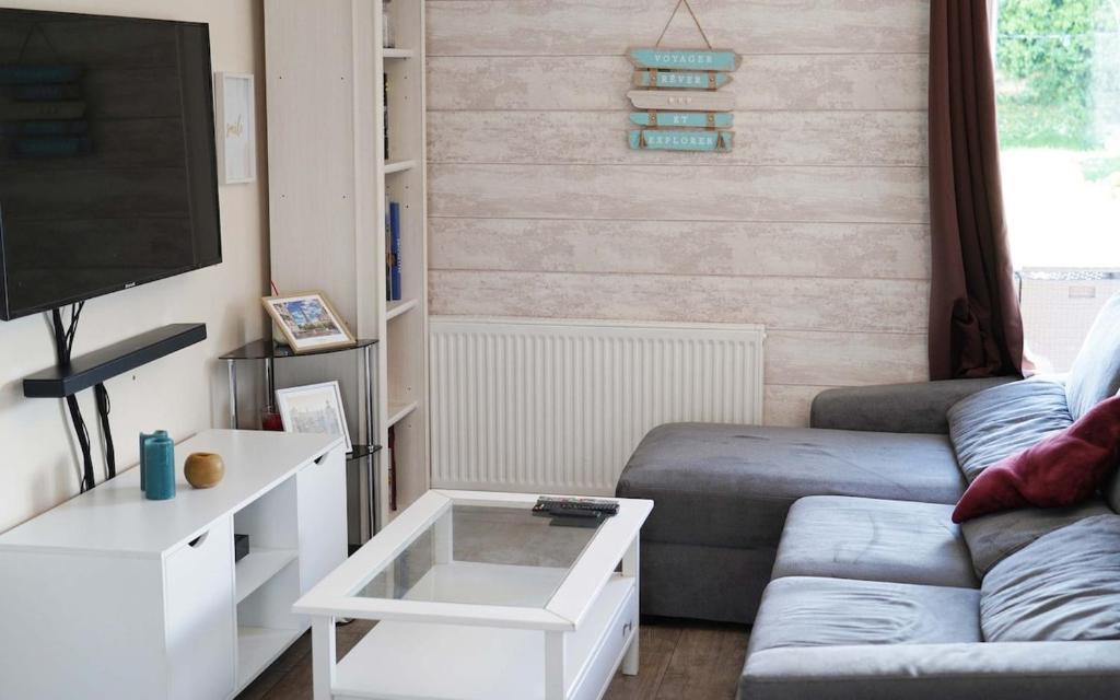 a living room with a couch and a flat screen tv at Le Petit Orme in Chartres