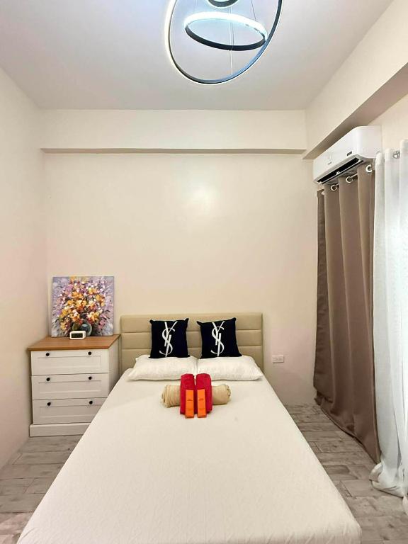 a bedroom with a large white bed with two pillows at Thyme Residence The VAs Nest Near Anjo World Free Pool and Gym in Minglanilla