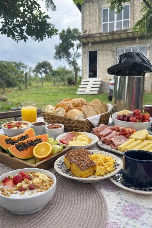 a table with many plates of food on it at Chalé Florada d' Serra in Chapada dos Guimarães