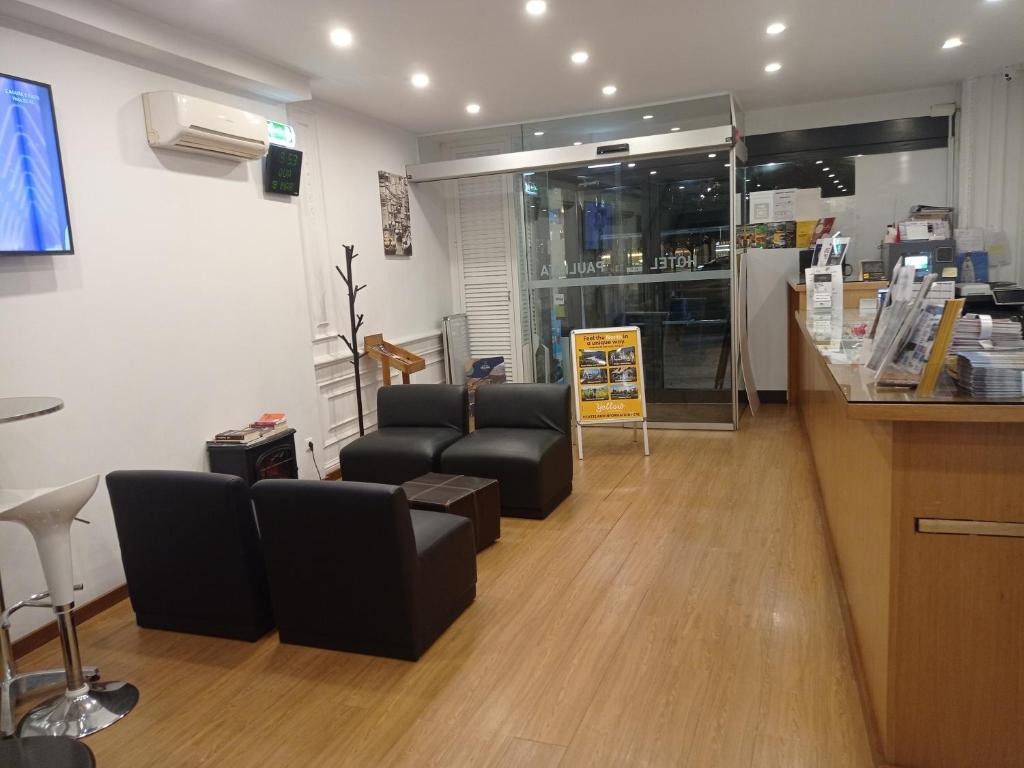 a waiting room with couches and chairs in a store at Hotel Paulista in Porto