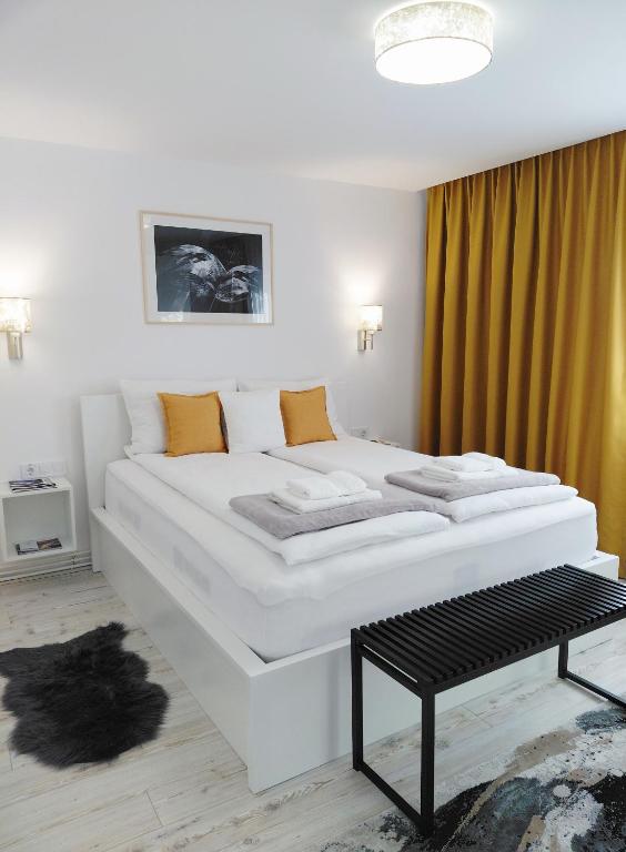 a bedroom with two white beds in a room at KM Art Apartman in Sfântu-Gheorghe