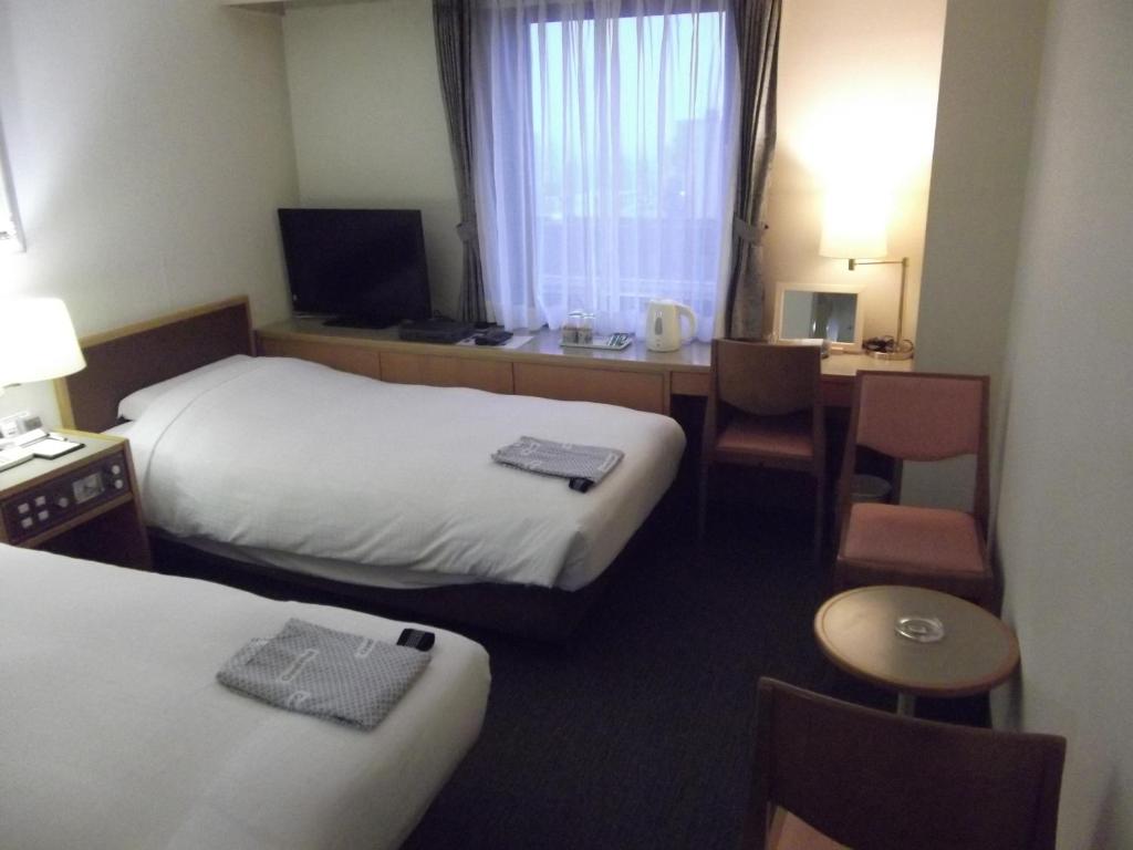 Postel nebo postele na pokoji v ubytování Ichikawa Grand Hotel