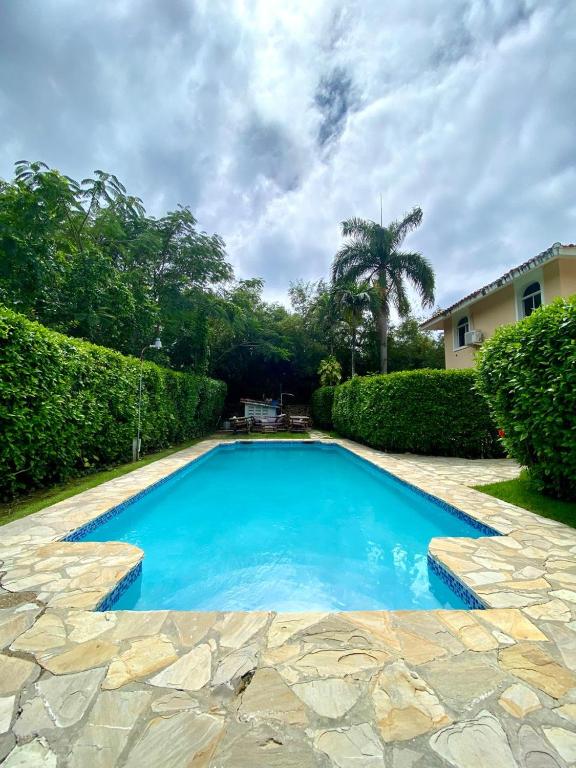 a large blue swimming pool with a stone walkway at Privat 3 bedroom apartment in Sosua