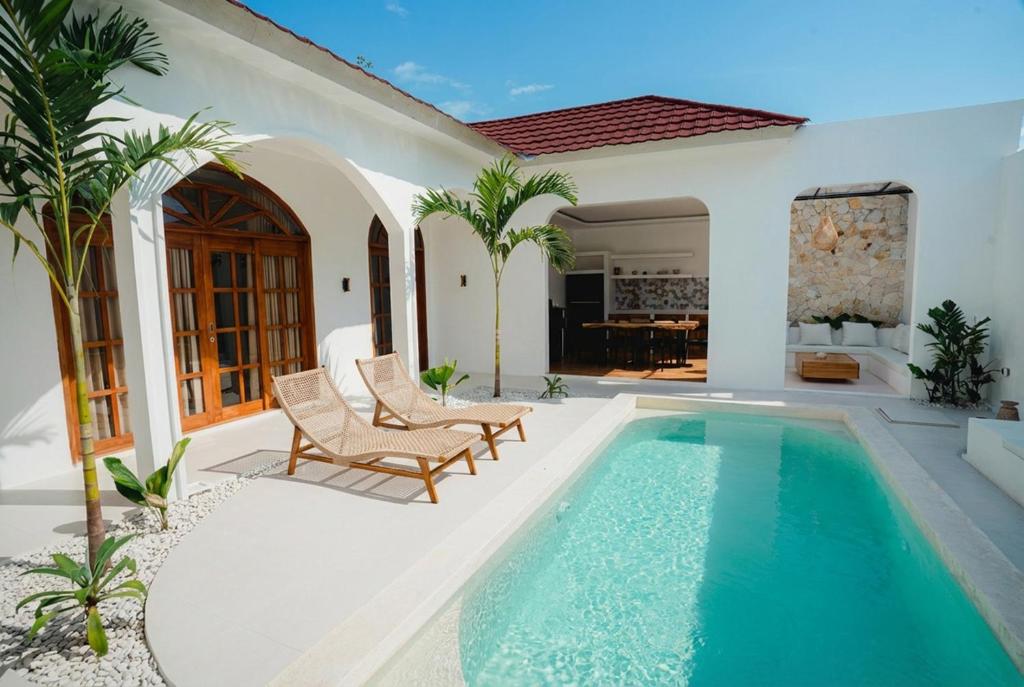a house with a swimming pool in a yard at Villa Charlotte in Selong Belanak