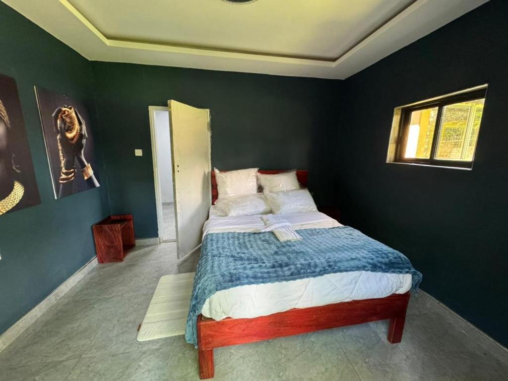 a bedroom with a bed in a green wall at Longacres Cottage in Lusaka