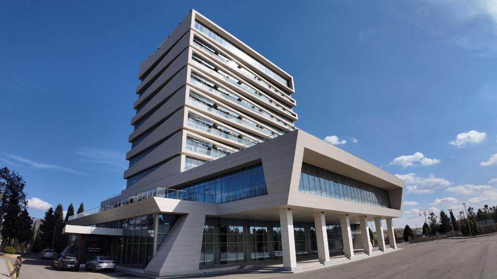 a tall building with a parking lot in front of it at Naftalan Central Wellness Resort in Naftalan