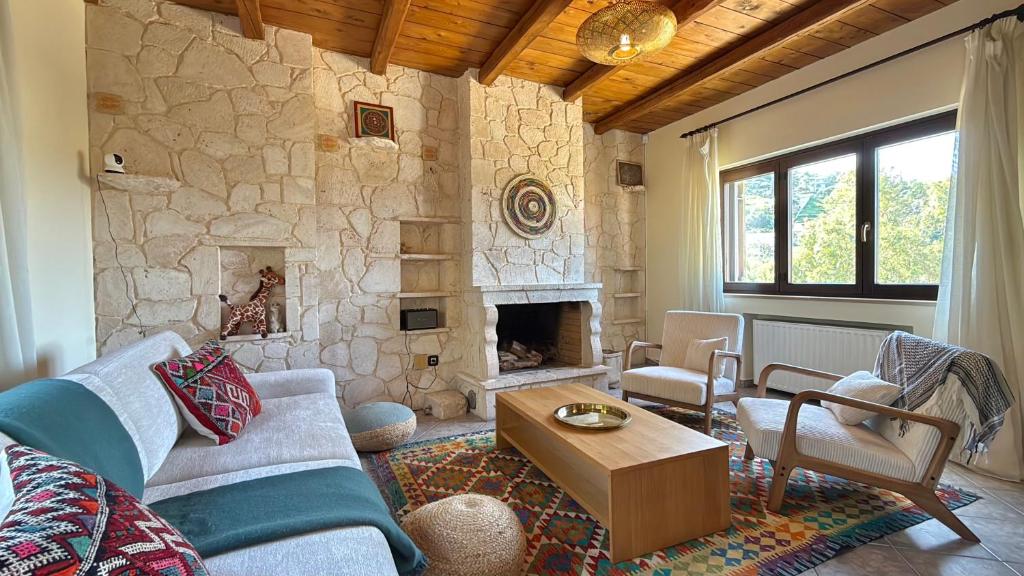a living room with a couch and a stone fireplace at The Jasmine Hill in Aegenitissa
