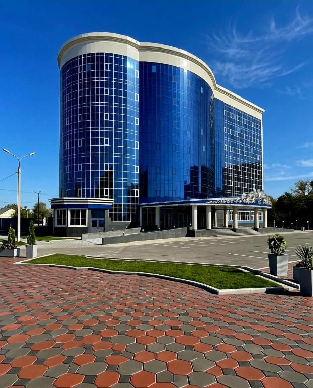 a large blue building with a red brick at Monotel Hotel in Ustʼ-Kamenogorsk