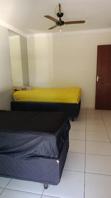 two beds in a room with a ceiling fan at exclusivamente para agrishow e João rok in Ribeirão Preto