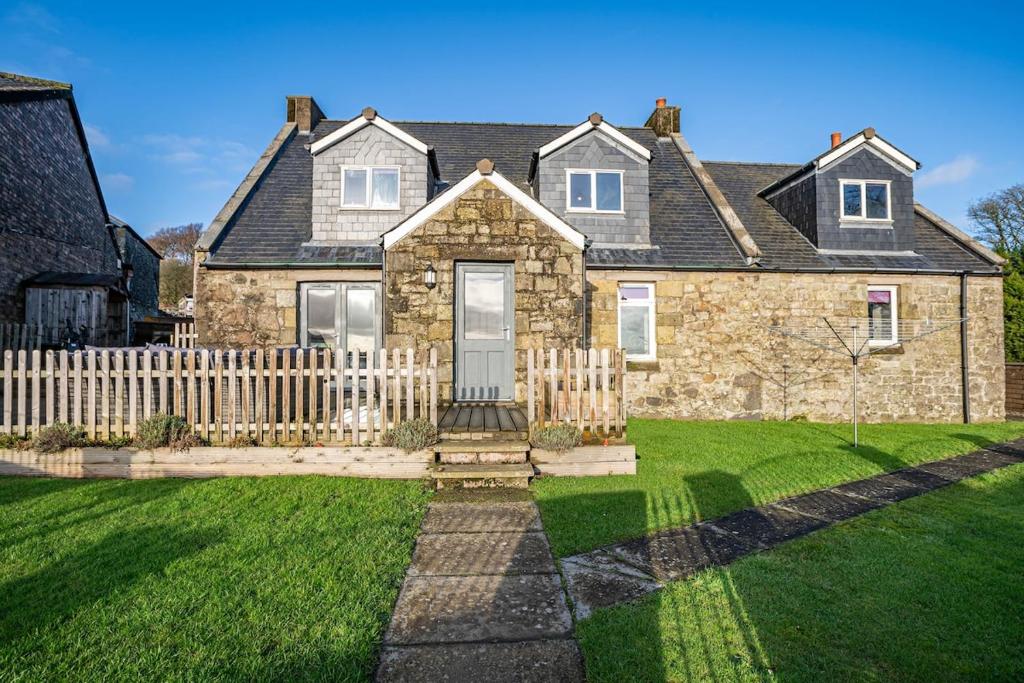 a house with a wooden fence in the yard at Ballo Cottage - Stunning views in Leslie