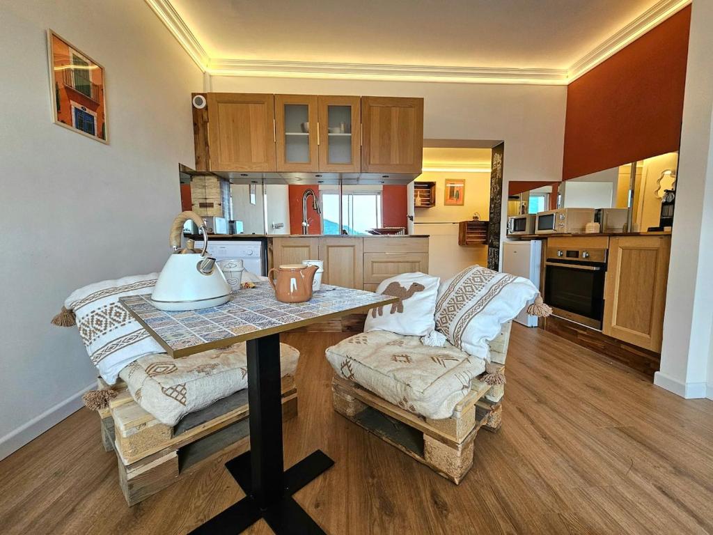 a kitchen with a table and a couch in a room at Studio cosy - Porte de Genève & Voie Verte in Ambilly