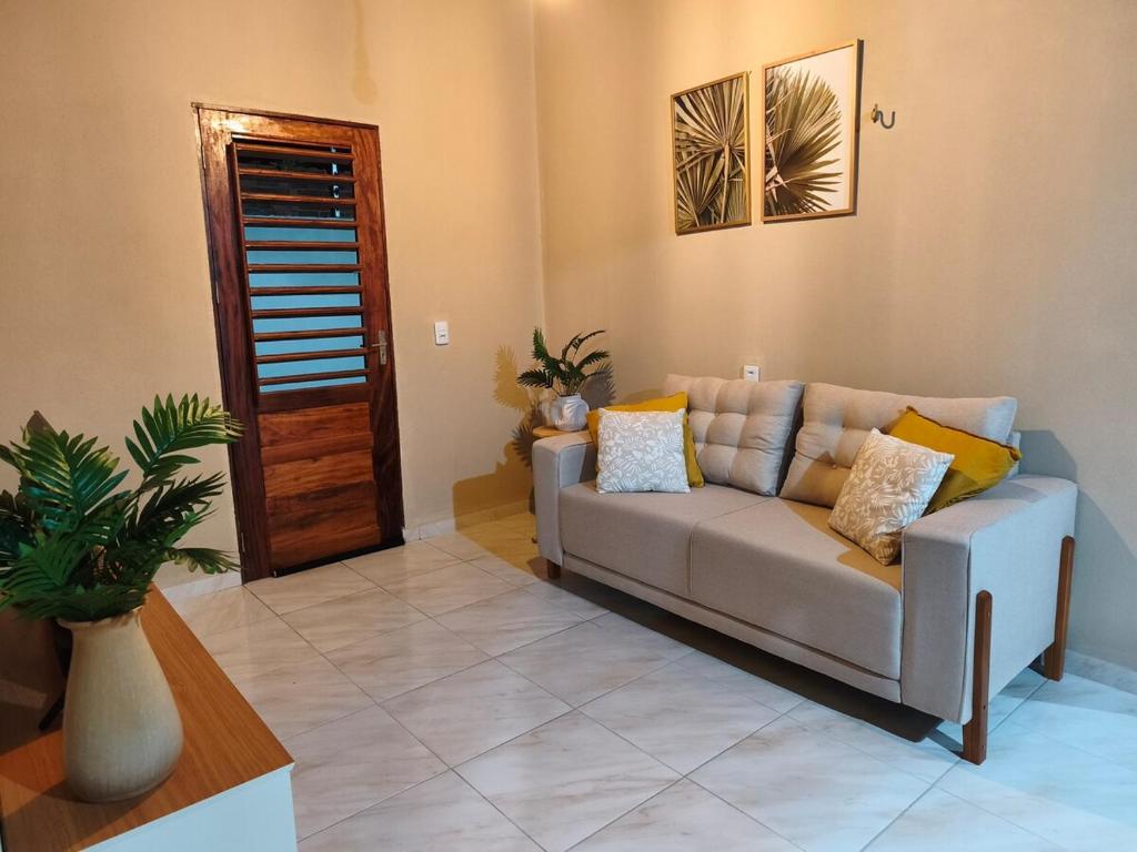 a living room with a couch and a plant at Casa Tito in Cascavel