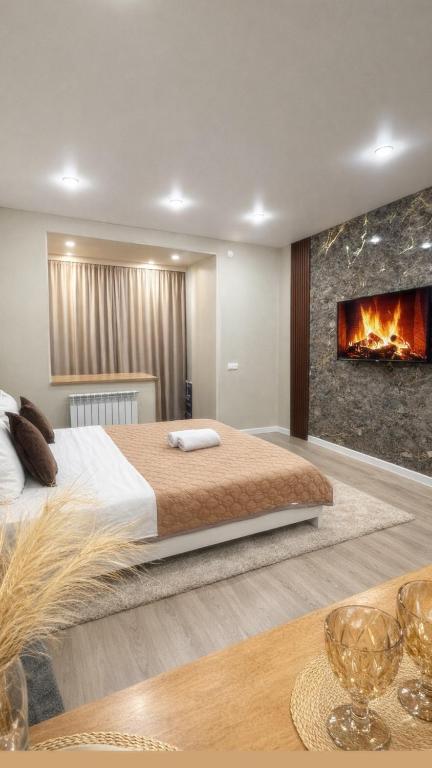 a bedroom with a large bed and a fireplace at Новое ЖК in Semey
