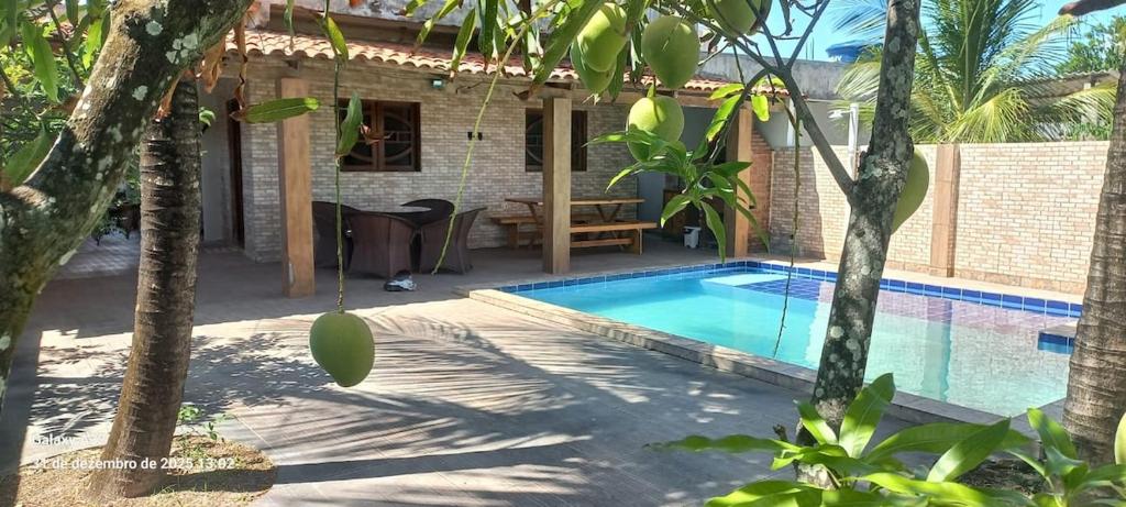 a swimming pool in front of a house at Aconchego das Araras in Sirinhaém