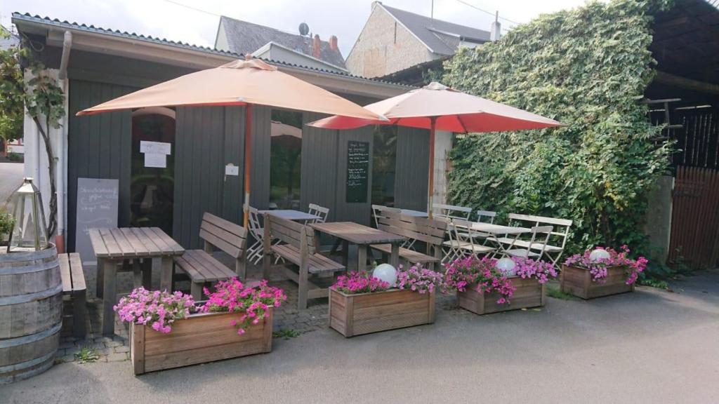 a patio with tables and umbrellas and flowers at Weingut Harald Konrad Fehres in Brauneberg