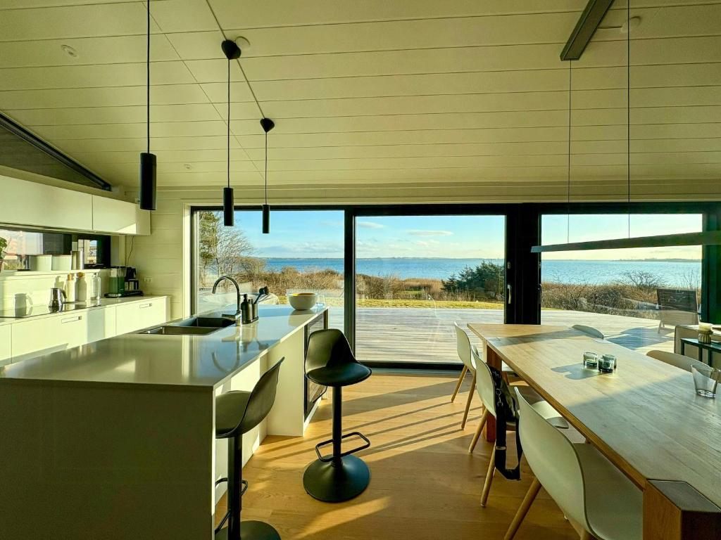 a kitchen with a table and a large window at Idyllic Modern House Overlooking Lammefjord in Vig