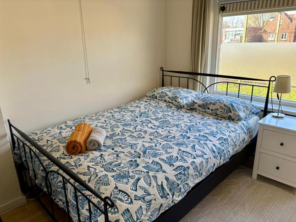 a bedroom with a bed with a blue and white comforter at Nijmegen Cozy Guest Rooms in Nijmegen
