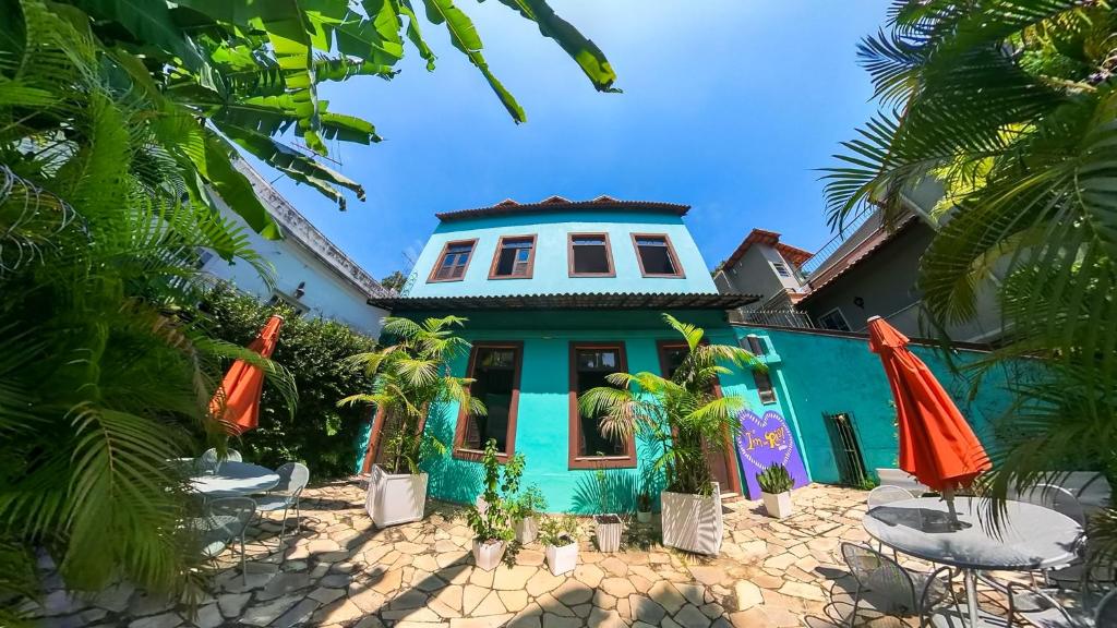 a blue house with palm trees in front of it at casaJOMO in Rio de Janeiro
