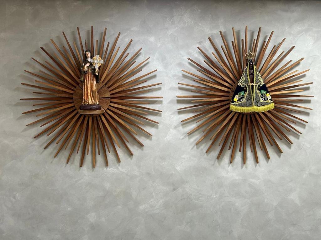 a pair of mirrors with a statue on a wall at Hotel Santa Clara in Aparecida