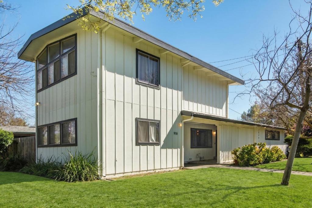 a white house with black windows and a yard at Spacious 4BR Backyard Oasis with BBQ Near UC Davis in Davis
