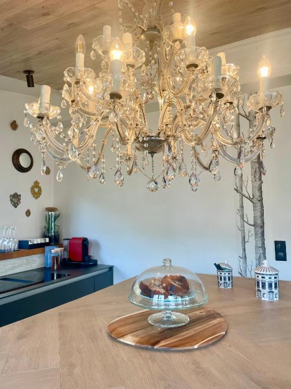 a glass plate on a table under a chandelier at La Noirie in Saint-Étienne