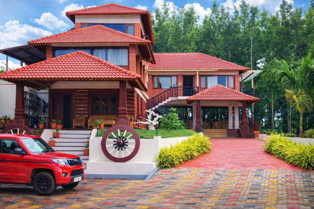 a house with a red car parked in front of it at Bougainvillea in Chikmagalūr