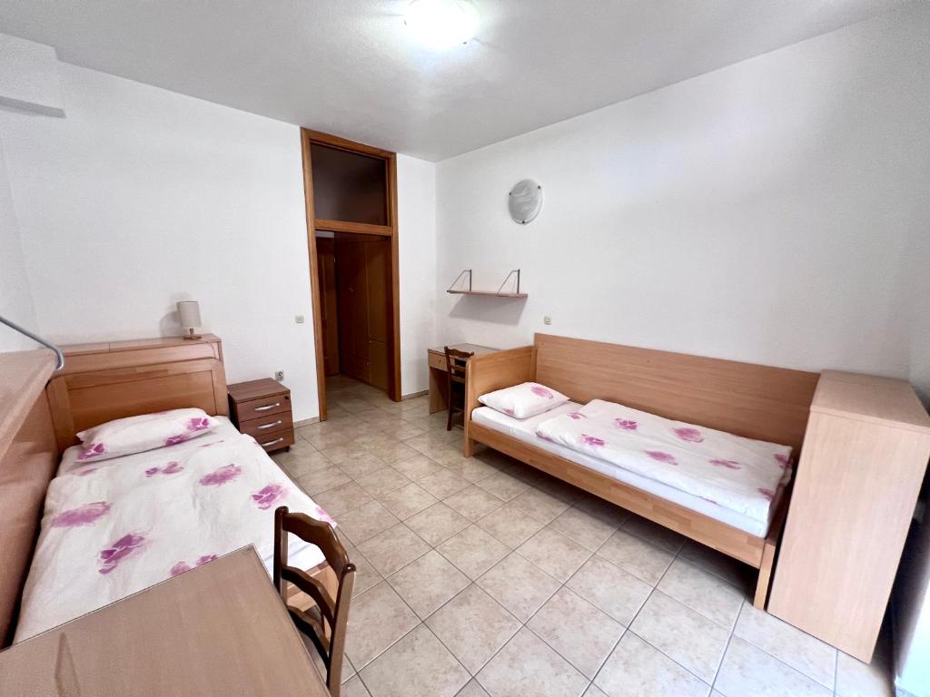 a bedroom with two beds and a desk in it at Paxora sobe - Mostar in Mostar