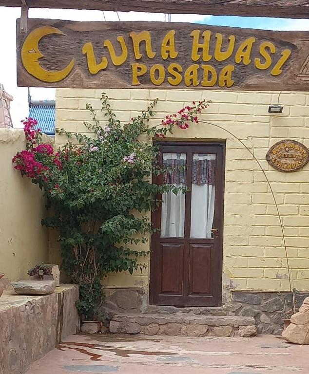 a building with a door and a sign on it at Luna Huasi Posada in Maimará