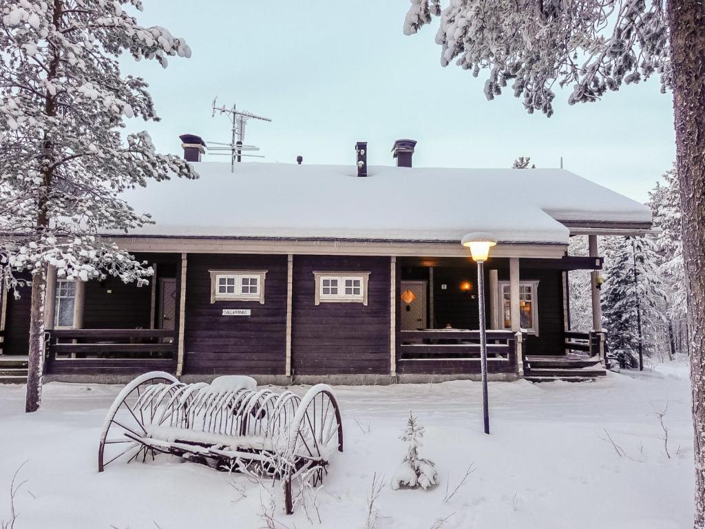 a bench in the snow in front of a building at Holiday Home Sallanrinne b by Interhome in Salla