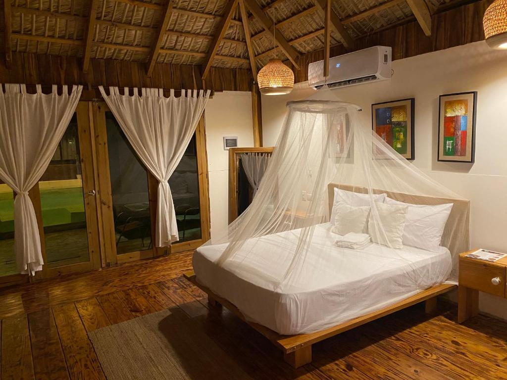 a bedroom with a bed with a mosquito net at Palmeras del valle in La Majagua