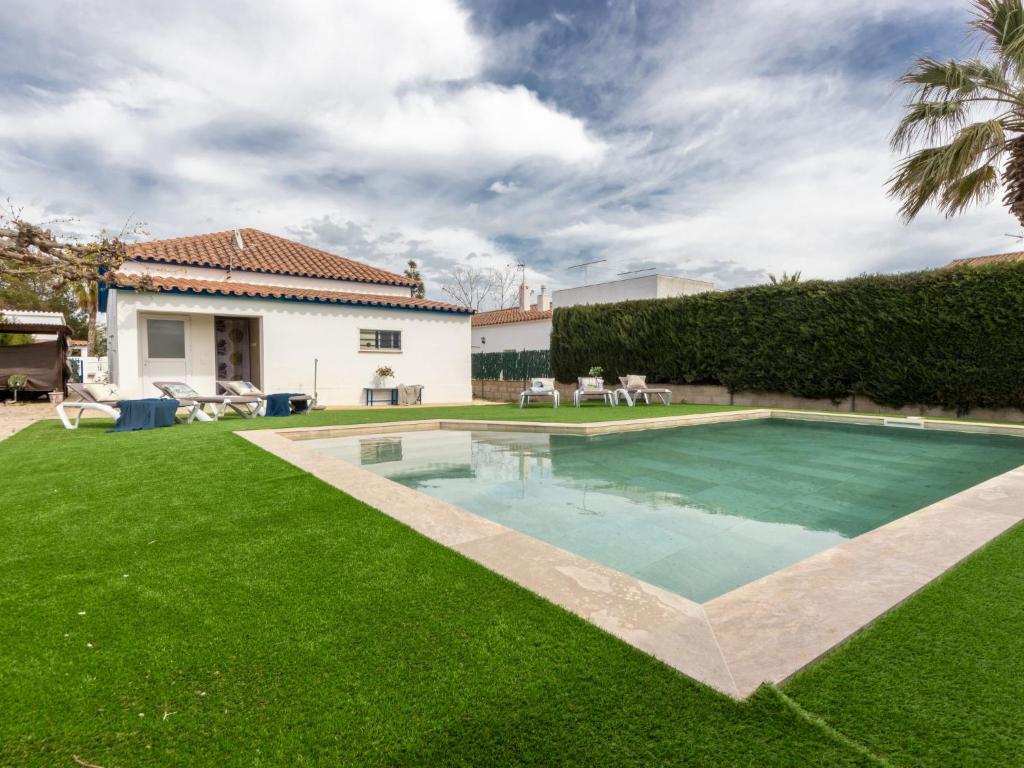 a backyard with a swimming pool and green grass at Holiday Home Stefania by Interhome in Riumar