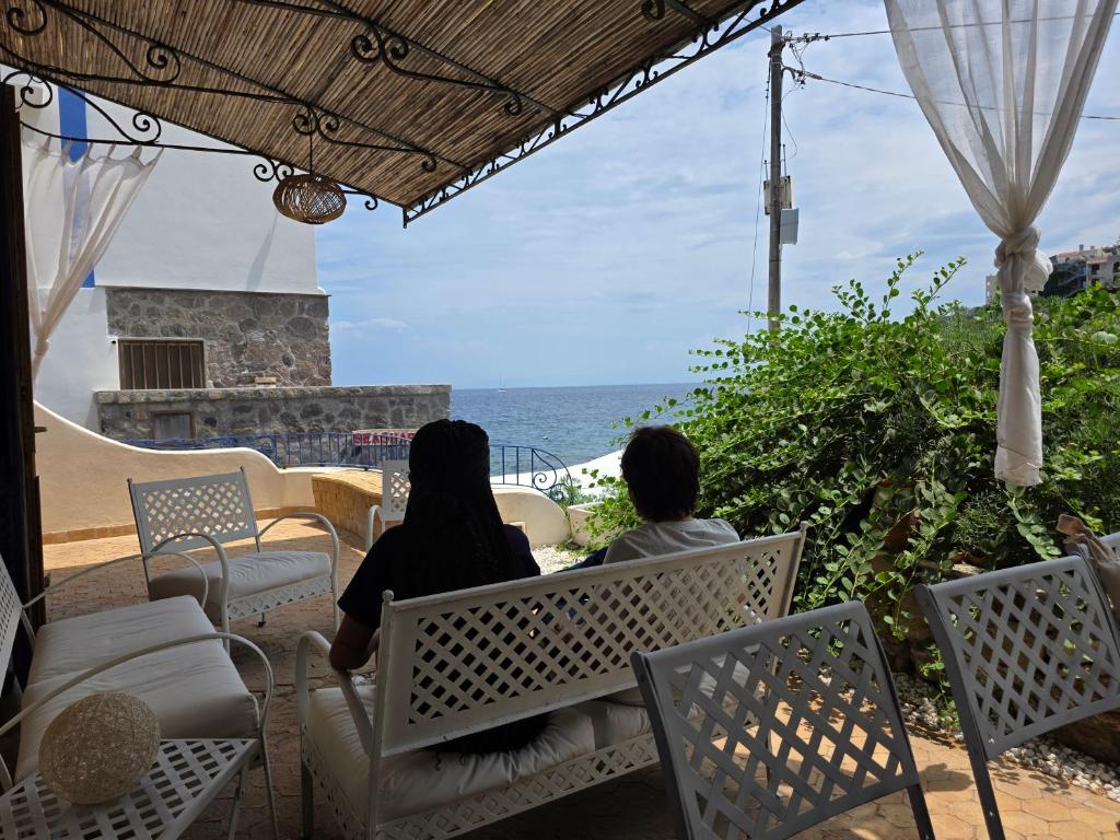 two women sitting on a bench looking at the ocean at Bedda Mia - Lipari in Lipari