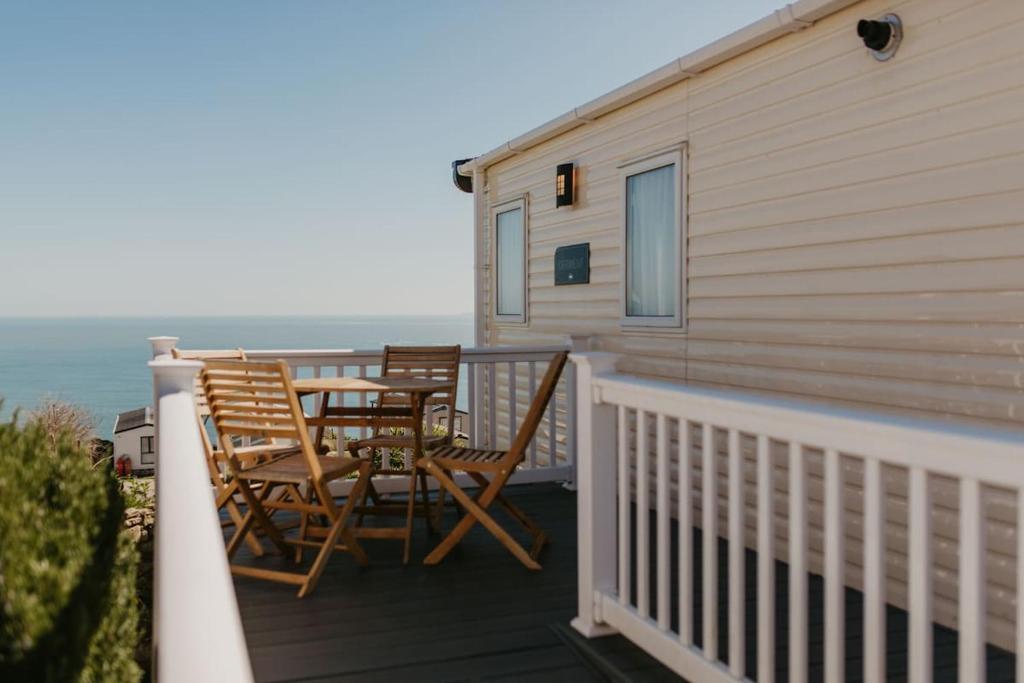 a balcony with two chairs and a table with the ocean at Upper Cliff 4 in Easton