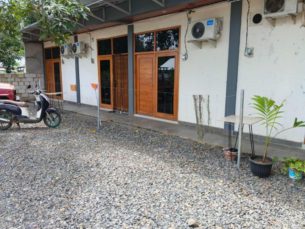 a scooter parked in front of a building at Cozzee AnD in Labuan Bajo