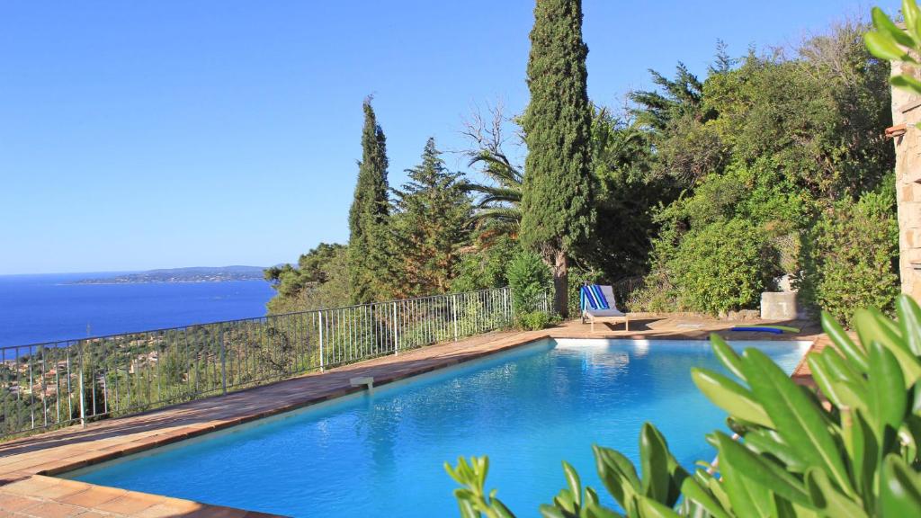 a swimming pool with a view of the water at Villa Lucienne in Les Issambres