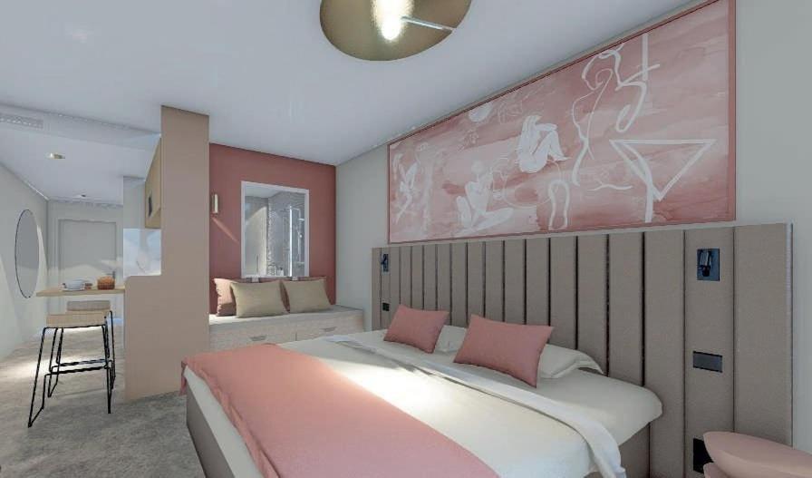a bedroom with a large bed and a pink wall at Le VIBES RESORT By AGN "réservé aux couples" in Cap d'Agde