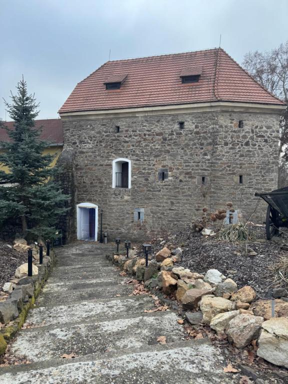 a stone building with a pathway in front of it at Penzion Bašta in Bílina