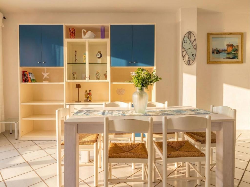 a dining room with a white table and chairs at Apartment Rais 13 by Interhome in Stintino