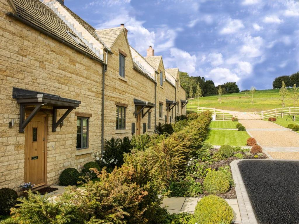 a row of brick houses with a garden at 2 Bed in Chipping Campden oc-78128 in Chipping Campden