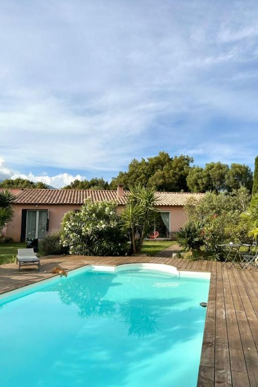a blue swimming pool in front of a house at Villa Tarabucetta by Interhome in Figari