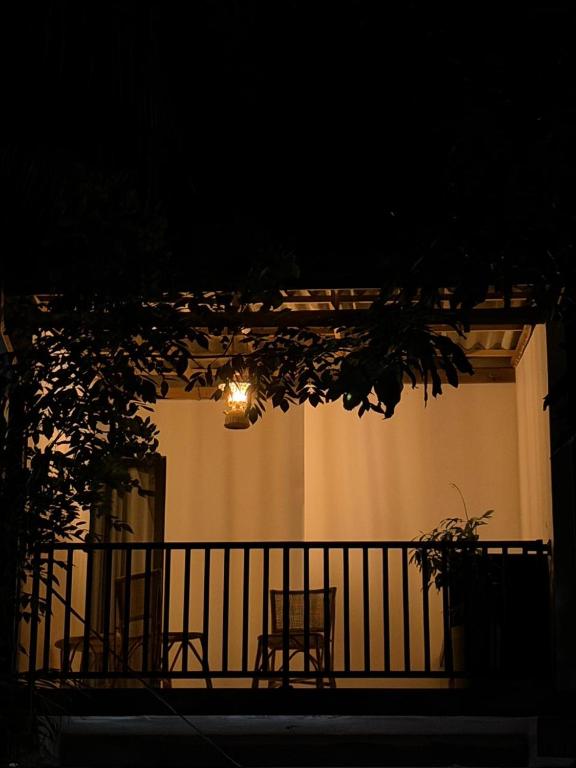 a balcony with two chairs and a light at night at City Villa Dikwella in Dickwella