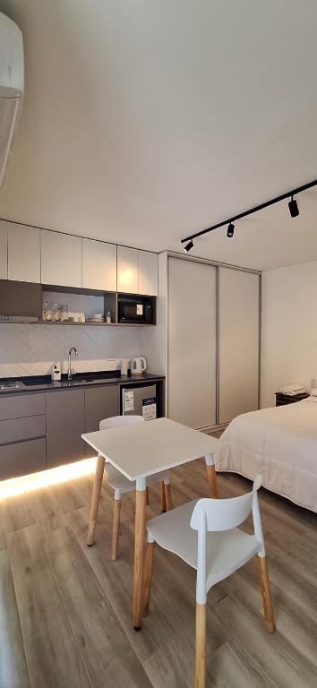 a room with a bed and a table and a kitchen at GyC Laguna Resort in Chascomús