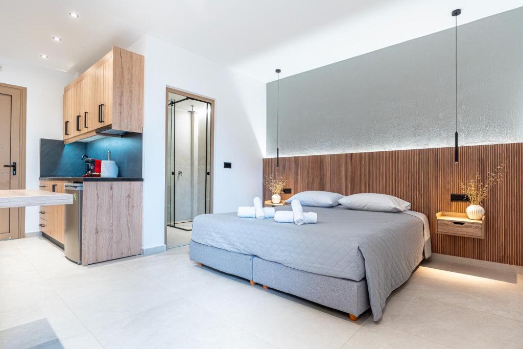 a bedroom with a large bed and a kitchen at Elysian Studio A4 in Karpathos