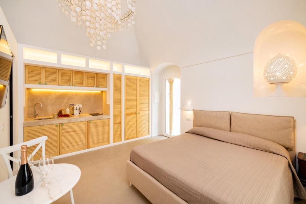 a bedroom with a bed and a table and a kitchen at Aria di Mare CENTER HOME in Vieste
