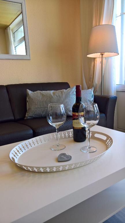 a table with two glasses and a bottle of wine at Strandliebe-I-mit-Balkon in Burgtiefe auf Fehmarn 