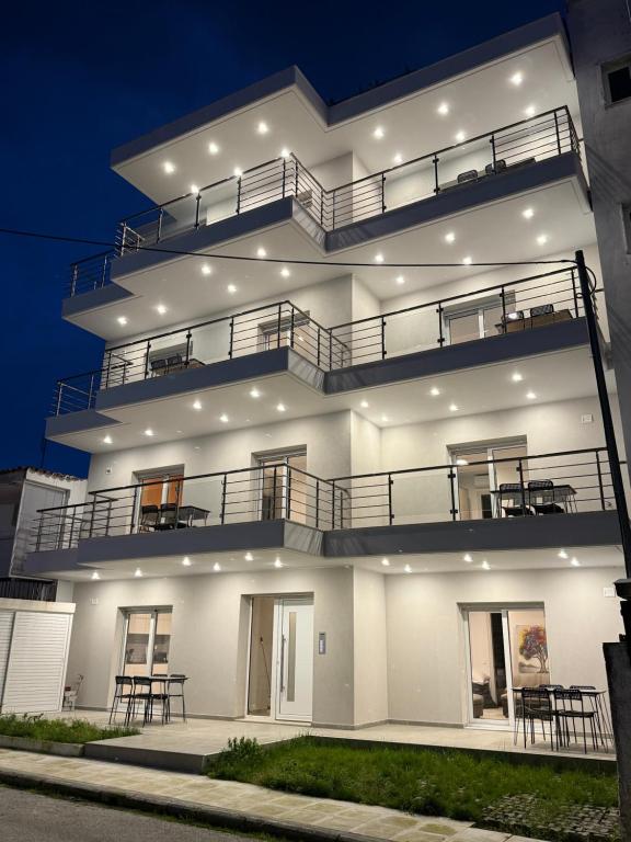 a large white building with several balconies on it at Villa Maria Apartments by BookVillaEU in Nea Kallikrateia