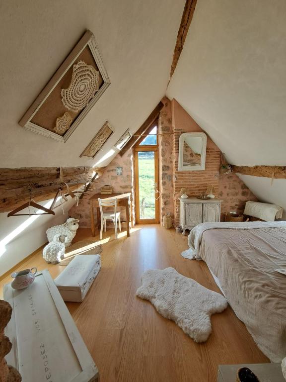 a attic bedroom with a bed and a window at Maison la Bambine chambre nature in Ozolles