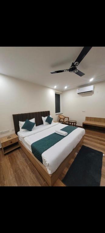 a bedroom with a large bed with green pillows at Hotel GS GRAND in Dehradun