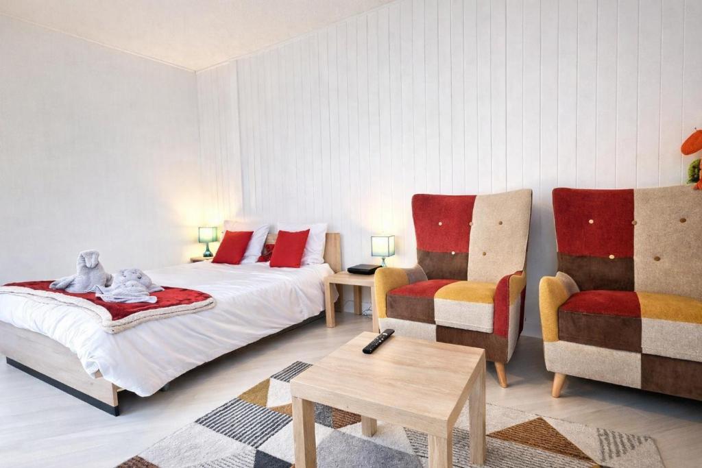 a bedroom with a bed and a chair and a table at 5 Mins to Train Station - Free Parking - DisneyLand - Escapade Perchée in Pomponne